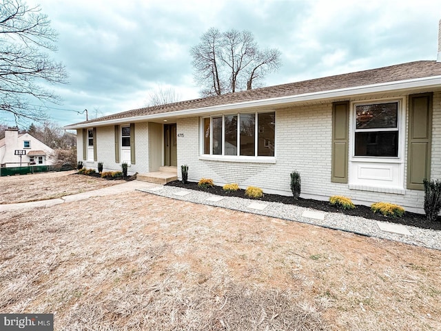 ranch-style house featuring brick siding