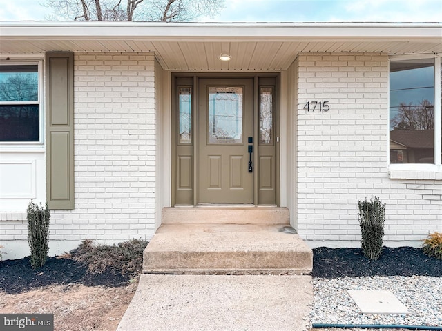 view of exterior entry featuring brick siding