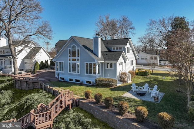 back of house featuring an outdoor fire pit, a yard, a shingled roof, a chimney, and a patio area