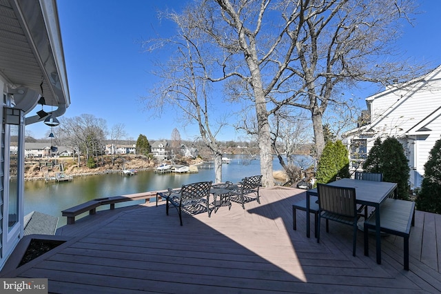 wooden deck featuring a water view and outdoor dining space