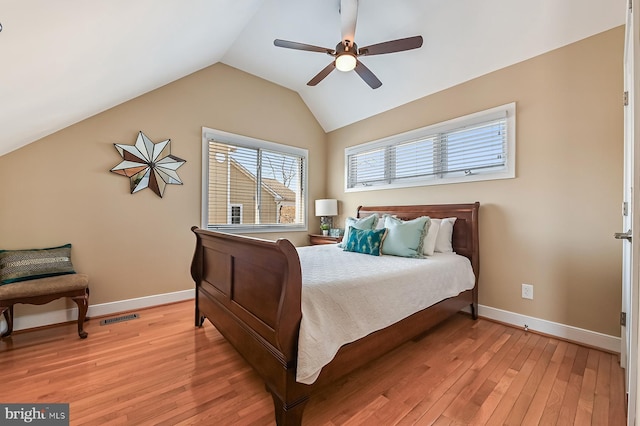 bedroom featuring visible vents, light wood-style flooring, baseboards, lofted ceiling, and ceiling fan