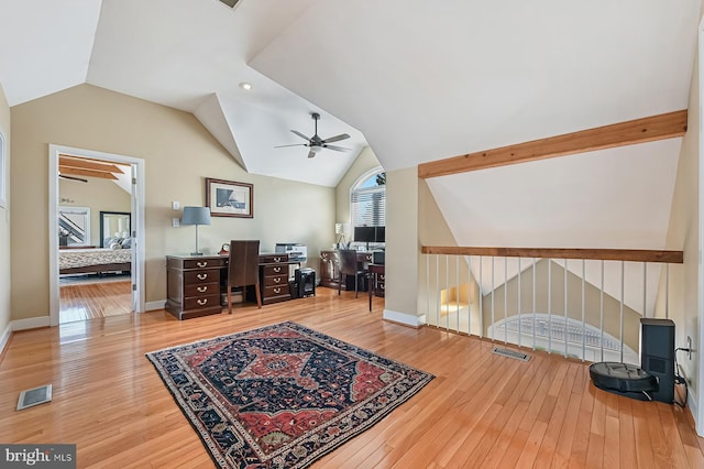 office with vaulted ceiling, visible vents, baseboards, and hardwood / wood-style flooring