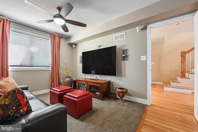 living area featuring stairway, baseboards, visible vents, and wood finished floors