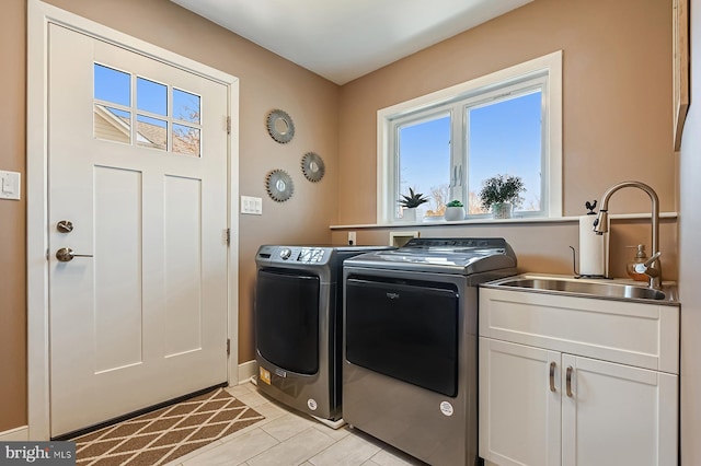 laundry room featuring a sink, cabinet space, separate washer and dryer, and plenty of natural light