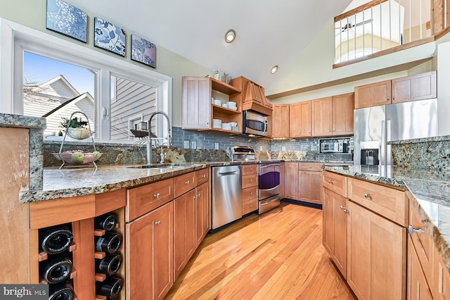 kitchen with open shelves, stone countertops, a sink, backsplash, and appliances with stainless steel finishes