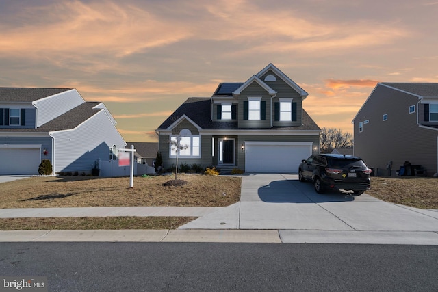 traditional home featuring concrete driveway and an attached garage