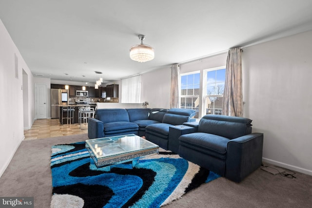 living area featuring light colored carpet and baseboards