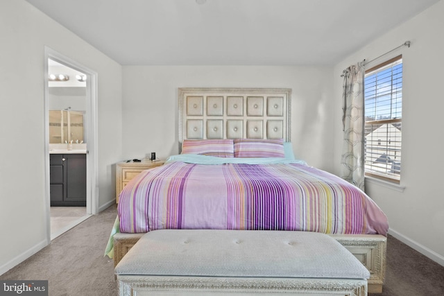 bedroom featuring ensuite bath, baseboards, carpet floors, and a sink