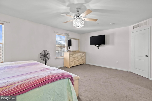 carpeted bedroom featuring a ceiling fan, visible vents, and baseboards