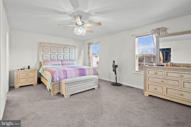 carpeted bedroom with baseboards, multiple windows, visible vents, and ceiling fan