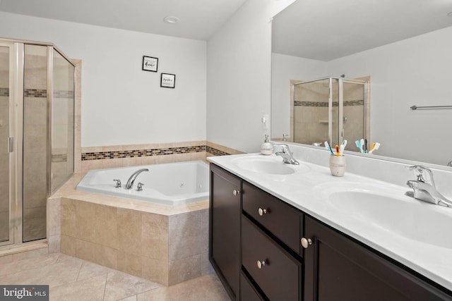 bathroom featuring tile patterned floors, a tub with jets, a stall shower, and a sink