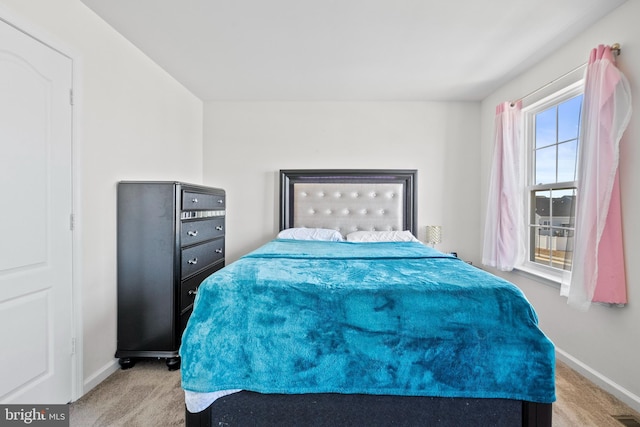 bedroom with light carpet, visible vents, and baseboards