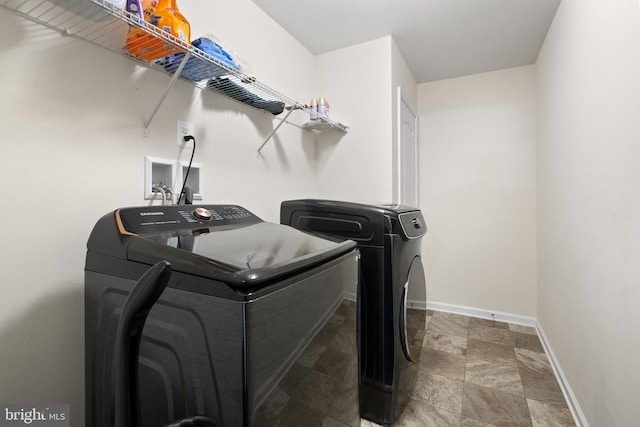 laundry room with laundry area, independent washer and dryer, and baseboards