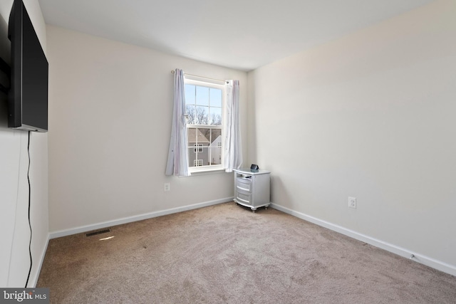 carpeted empty room with visible vents and baseboards