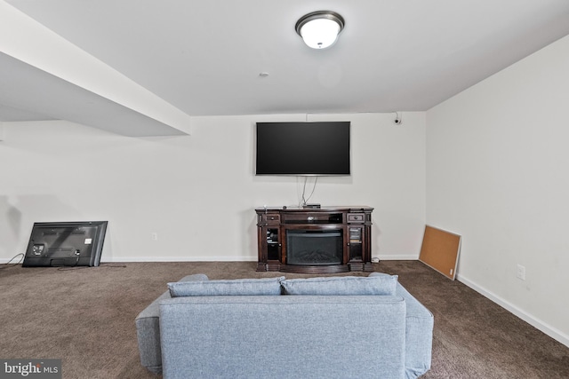 living room featuring baseboards and dark carpet