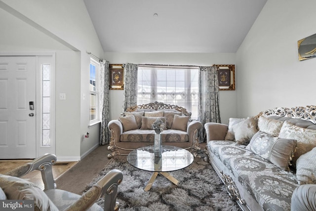 carpeted living room with vaulted ceiling and baseboards