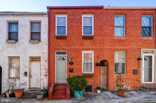 townhome / multi-family property featuring entry steps and brick siding