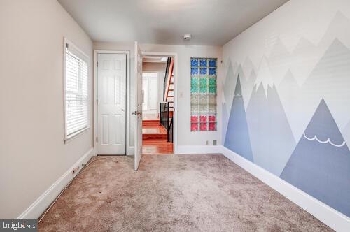 unfurnished bedroom with carpet flooring and baseboards