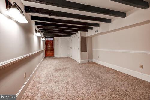 interior space with carpet flooring, electric panel, and baseboards