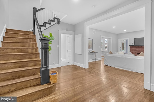 entryway featuring stairs, recessed lighting, visible vents, baseboards, and hardwood / wood-style flooring