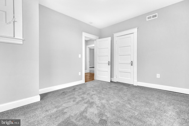 unfurnished bedroom featuring carpet, visible vents, and baseboards