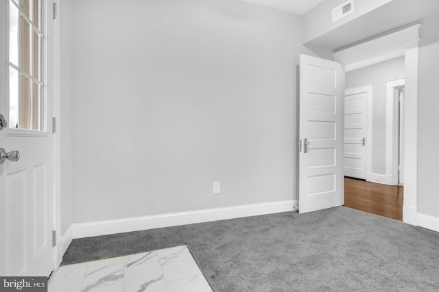 unfurnished bedroom with carpet floors, baseboards, and visible vents