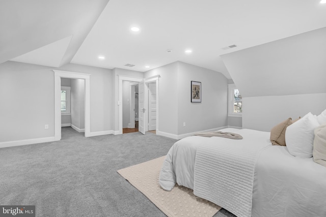 carpeted bedroom featuring visible vents, vaulted ceiling, baseboards, and multiple windows