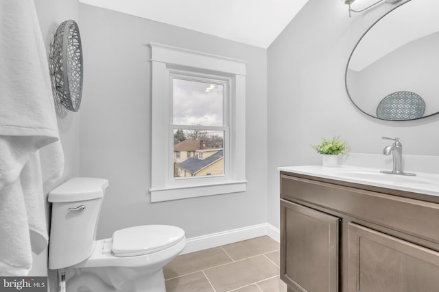 bathroom with baseboards, vanity, toilet, and tile patterned floors