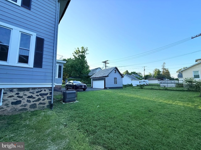 view of yard with a garage and central AC unit