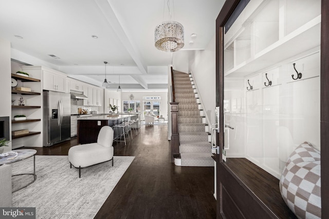 interior space with a chandelier, recessed lighting, stairs, beam ceiling, and dark wood-style floors