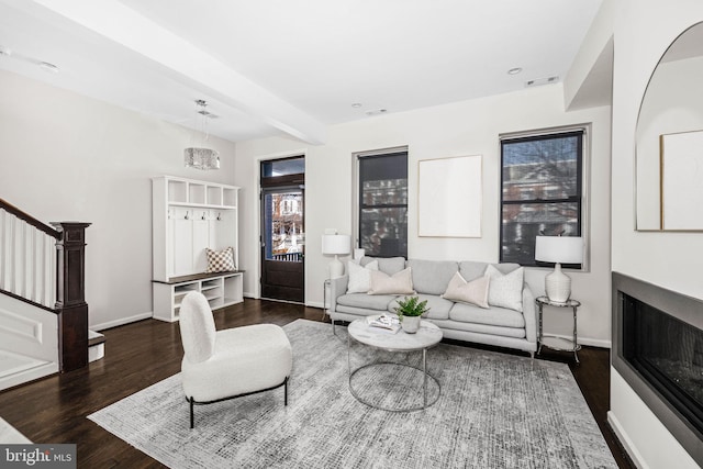 living room with visible vents, stairs, baseboards, and wood finished floors