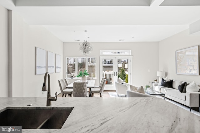 living room with a chandelier and french doors