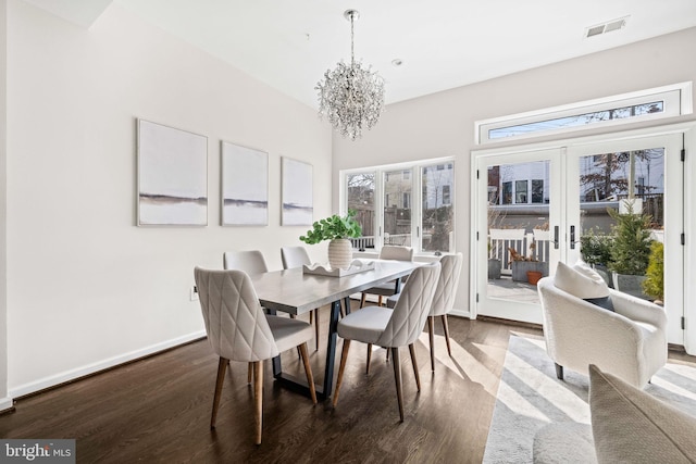 dining space featuring dark wood-style floors, french doors, visible vents, a chandelier, and baseboards