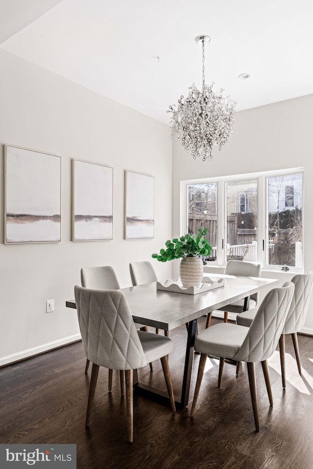 dining room featuring dark wood-style floors, a chandelier, and baseboards