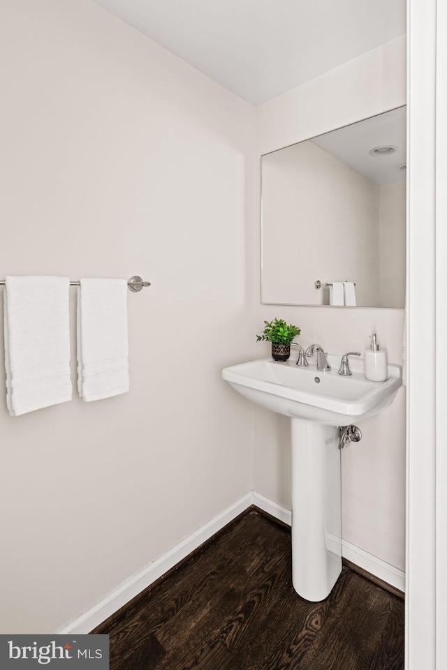 bathroom with baseboards and wood finished floors