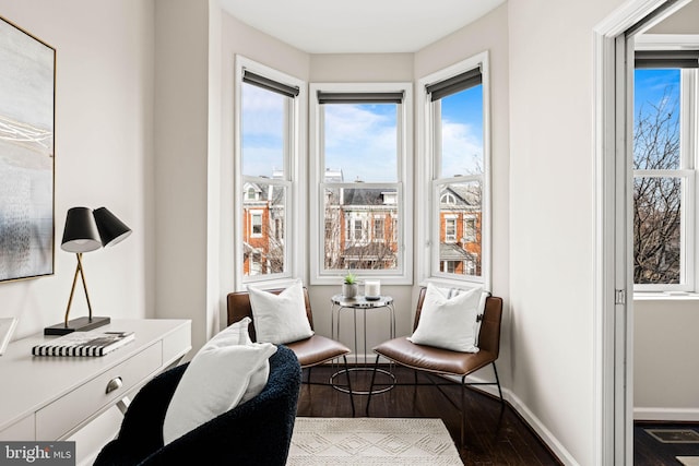 sitting room featuring dark wood-style floors, visible vents, and baseboards