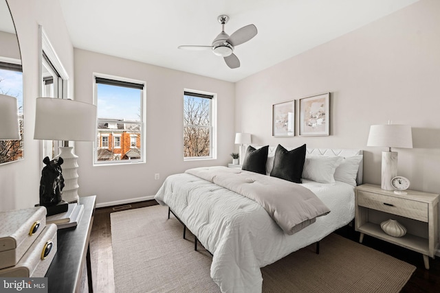 bedroom featuring wood finished floors, a ceiling fan, and baseboards