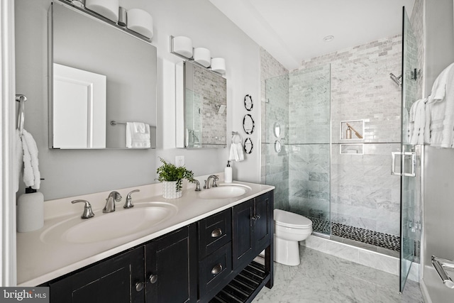 bathroom featuring a stall shower, a sink, toilet, and double vanity