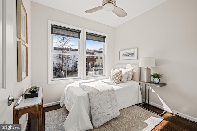 bedroom featuring a ceiling fan, baseboards, and wood finished floors