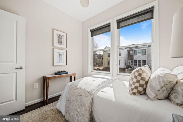 bedroom featuring access to outside, baseboards, and wood finished floors