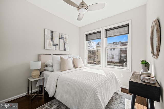 bedroom featuring dark wood-style floors, baseboards, and a ceiling fan