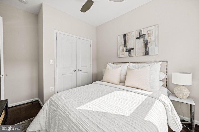 bedroom featuring a ceiling fan, a closet, baseboards, and wood finished floors