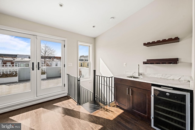 bar featuring beverage cooler, dark wood-style flooring, plenty of natural light, and a sink