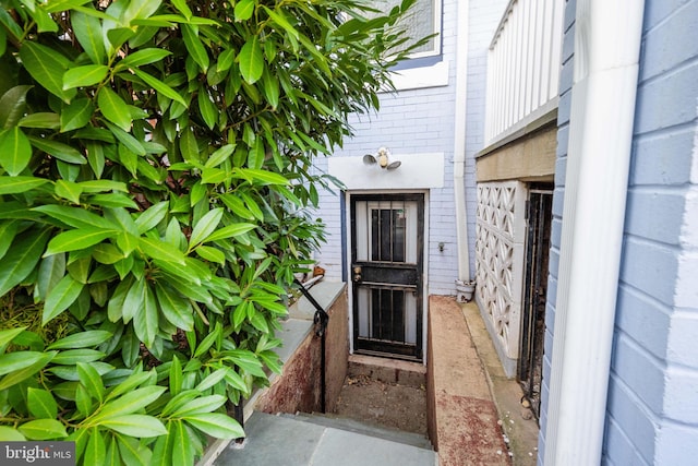 entrance to property featuring brick siding