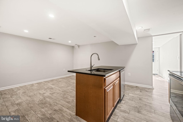 kitchen featuring dark countertops, visible vents, appliances with stainless steel finishes, brown cabinetry, and a sink