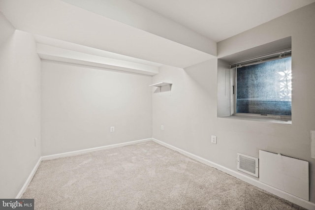 carpeted empty room featuring baseboards and visible vents