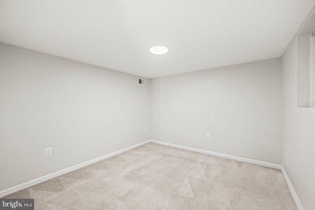 spare room with baseboards, visible vents, and carpet flooring