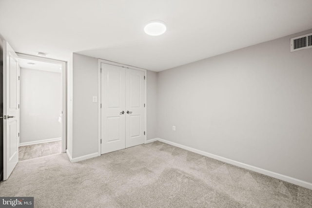 unfurnished bedroom featuring carpet, a closet, visible vents, and baseboards