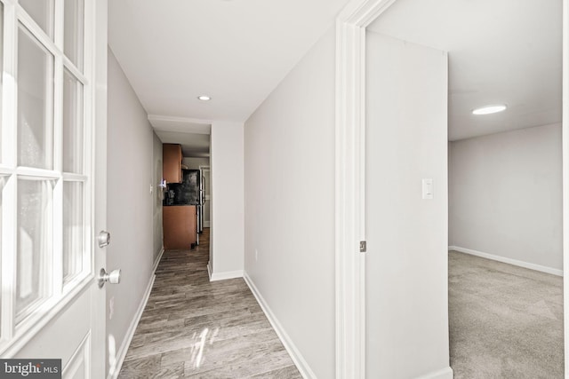 hall featuring recessed lighting, wood finished floors, and baseboards