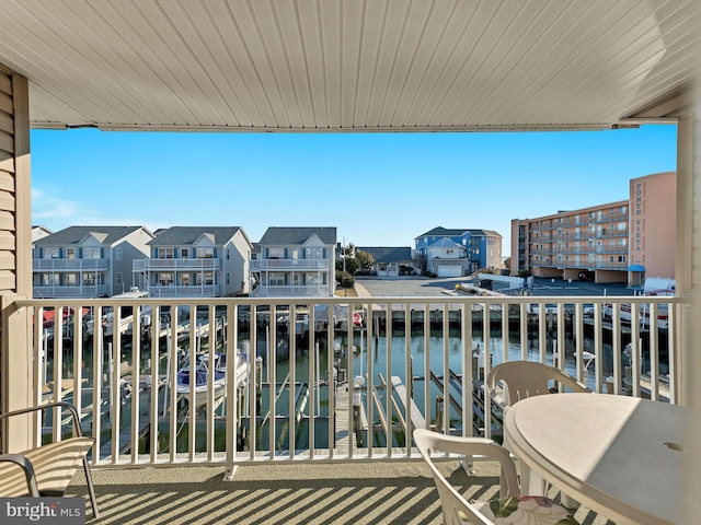 balcony with a residential view and a water view